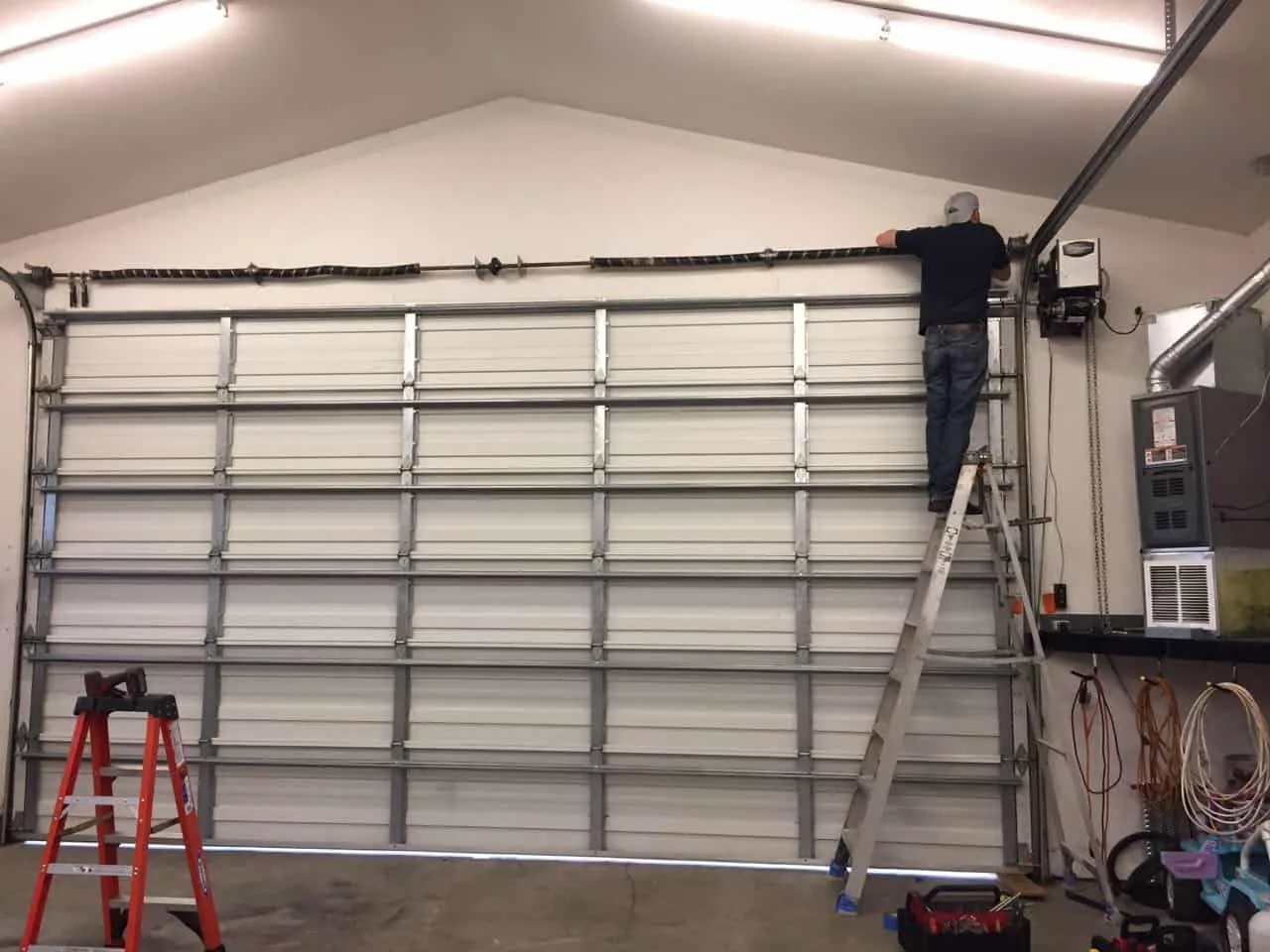 A&E technician servicing a garage door torsion spring system