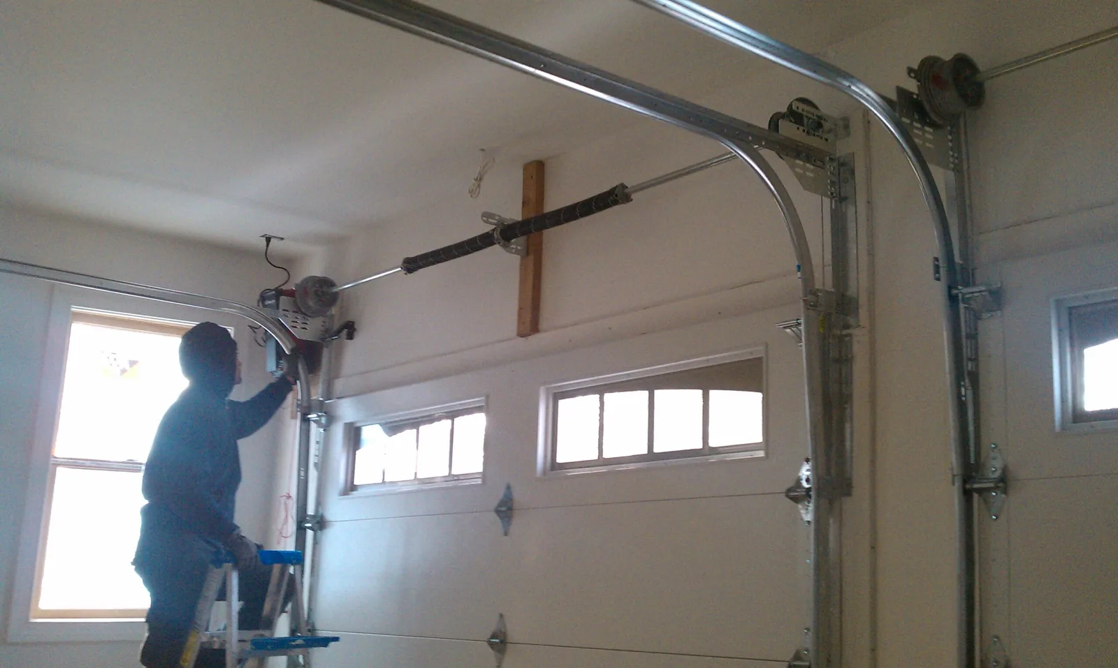 A&E technician servicing a garage door torsion spring